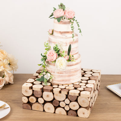 Three-tier wedding cake decorated with flowers on a wooden cake stand.