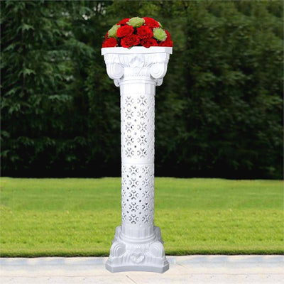 White decorative column with red flowers on top, set against a green background.