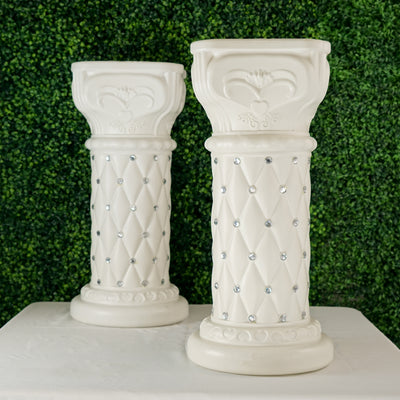 Elegant white decorative pillars with diamond accents on a green backdrop.