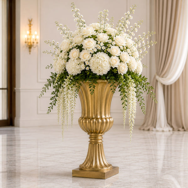 Elegant white floral arrangement in a gold pedestal vase in a luxury interior
