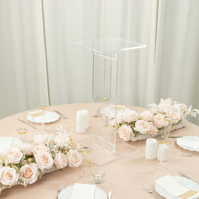 Clear acrylic display stand on a beautifully set dining table with floral decor.