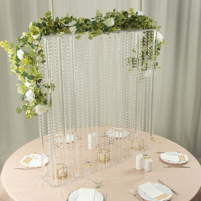 Elegant beaded curtain backdrop with greenery and flowers for event decor.
