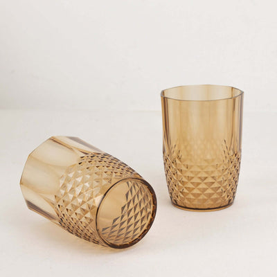 Amber diamond-patterned drinking glasses on a plain backdrop.