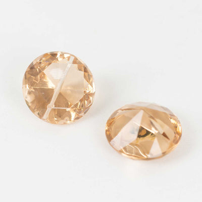 Peach crystal buttons on a white background