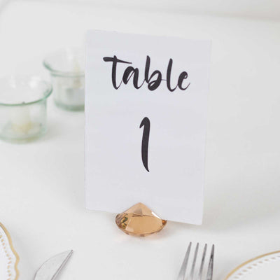 Table number sign in elegant script with a gold holder.