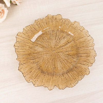 Amber decorative plate with a textured floral design on a light wooden surface.