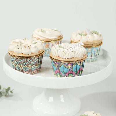 Colorful decorated cupcakes on a white cake stand.