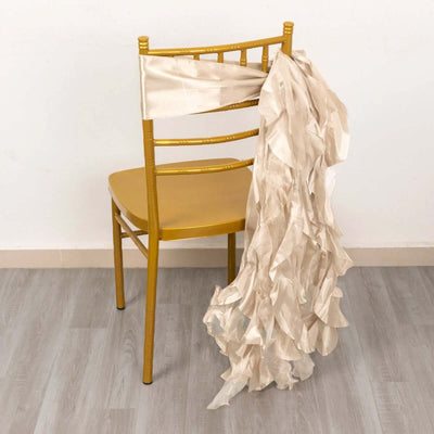 Gold chiavari chair with beige ruffled sash draped over the back.