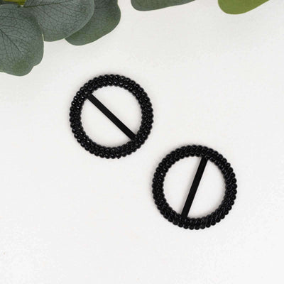 Black beaded hair clips arranged with greenery