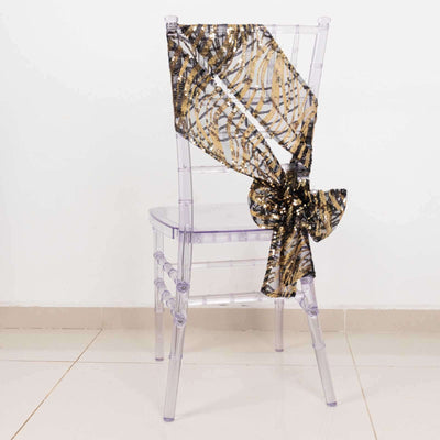 Transparent chair with a gold and black sequined bow on the back.