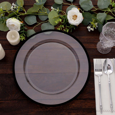Elegant clear charger plate set on a rustic wooden table with floral decor.