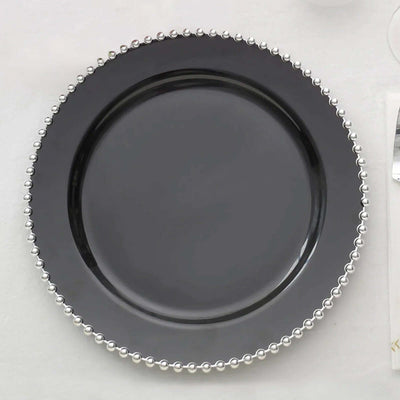 Black plate with silver bead trim on a plain background.