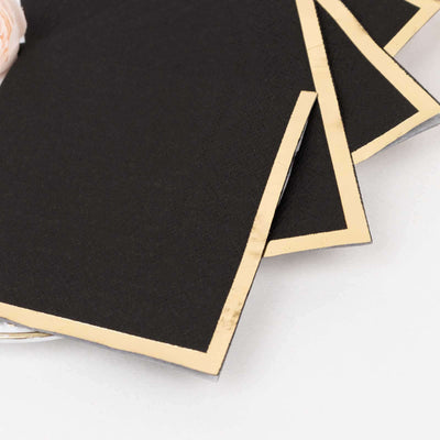 Black paper with gold edges, elegantly arranged.