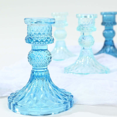 Blue glass candle holder with intricate design details.