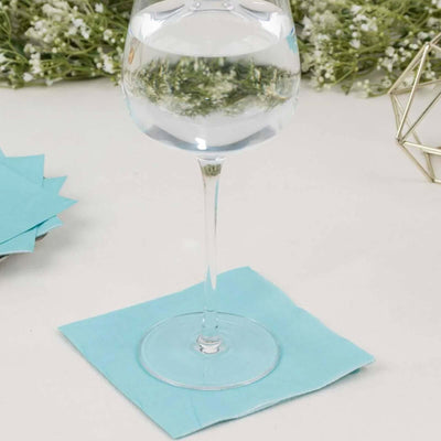 Clear glass of water on a blue napkin with decorative background elements.