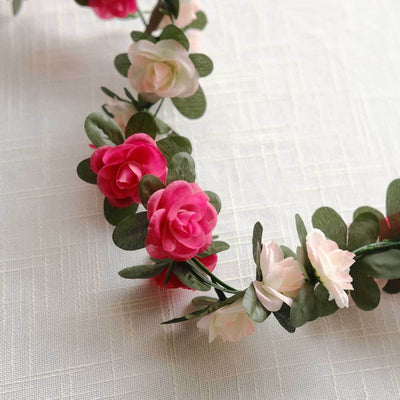 Colorful floral garland with pink and white flowers against a light background.