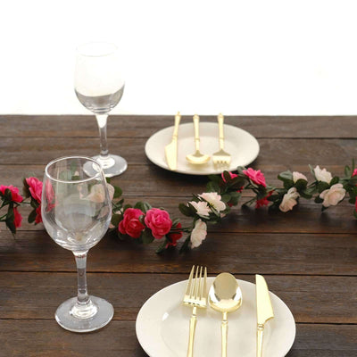Elegant gold cutlery set on a dining table with floral decor.