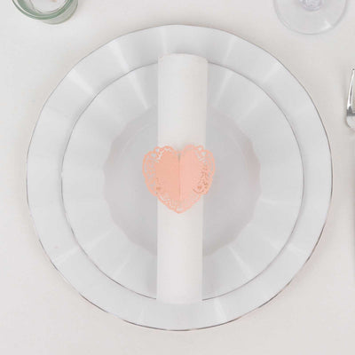 White plate with a rolled napkin and a heart-shaped lace holder.