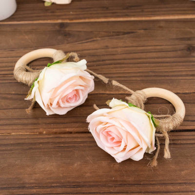 Wooden rings adorned with delicate pink roses and twine accents.