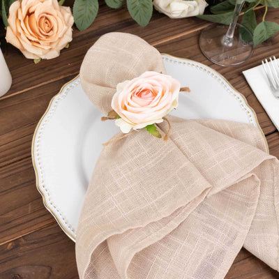 Elegant napkin tied with a rose on a decorative plate.