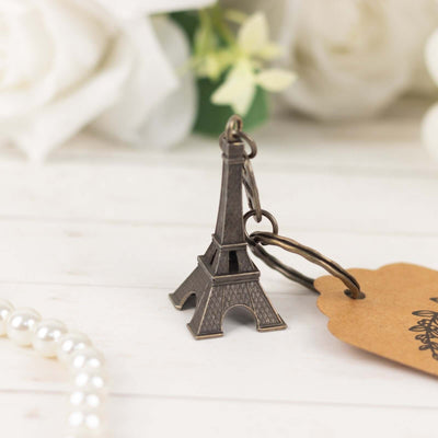 Eiffel Tower keychain with tag, styled with floral background.