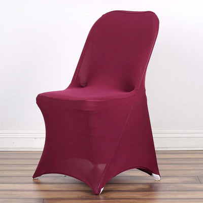 Maroon stretch chair cover on a wooden floor.