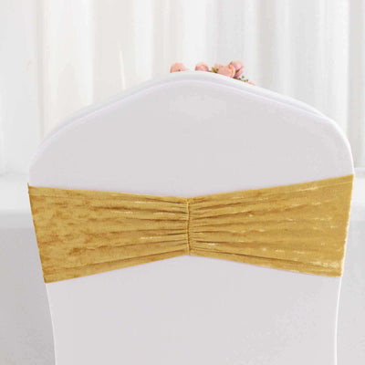 Gold chair cover sash with pleats on a white chair.