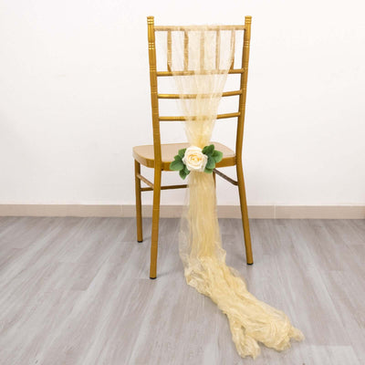 Gold chair with flowing yellow fabric and a decorative rose.