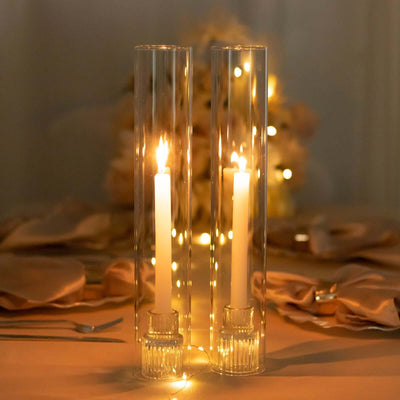 Elegant glass candle holders with lit candles, perfect for table decor.