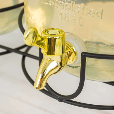 Gold beverage dispenser tap on a black metal stand