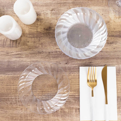 Clear decorative plates on a rustic wooden table with elegant cutlery.