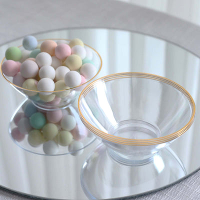 Clear glass bowls with gold trim, one filled with pastel-colored balls.