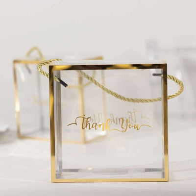 Clear acrylic gift box with gold "Thank You" lettering and decorative handle.