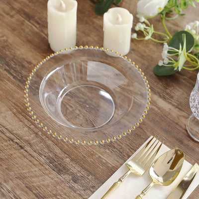 Clear glass plate with gold beaded rim on a wooden table setting.