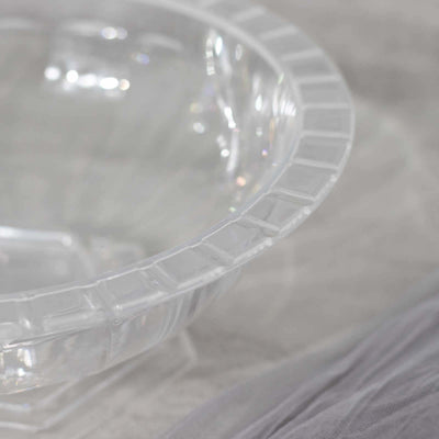 Clear glass bowl with geometric design and reflective surface.