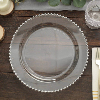 Clear glass plate with beaded edge on wooden table.
