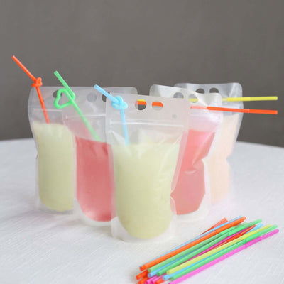 Colorful frozen drink pouches with straws on a table.