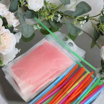 Colorful straws and pink ice pack on a mirror surface with floral decorations.