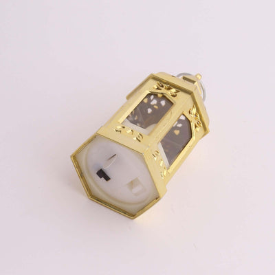 Gold decorative lamp holder with intricate design on a plain backdrop.