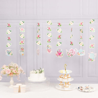 Tea party decorations with floral designs and teacups hanging decoratively.