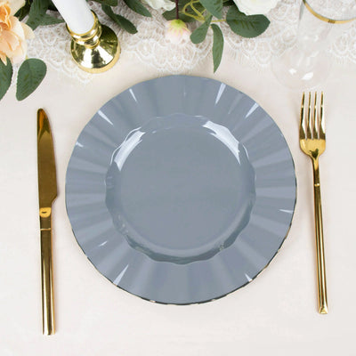 Gray decorative plate with scalloped edges, set on a table with elegant dining utensils.