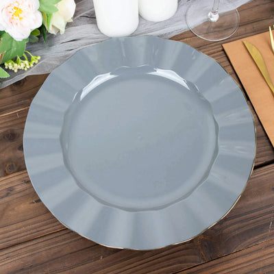 Gray decorative plate with a scalloped edge on a wooden table setting.
