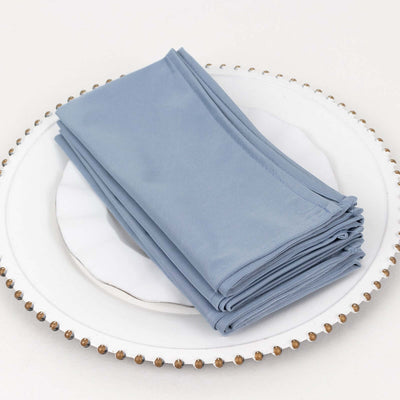 Blue fabric napkins stacked on a decorative plate.