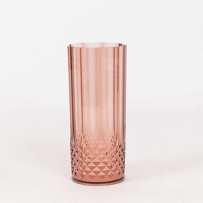 Pink crystal tumbler with geometric design on a white background.