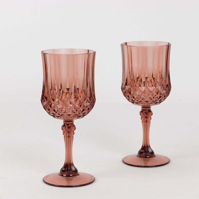 Set of two elegant pink crystal goblets on a plain backdrop.