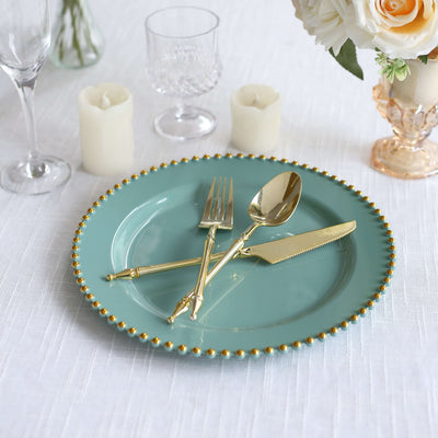 Elegant turquoise plate with gold utensils set for dining.