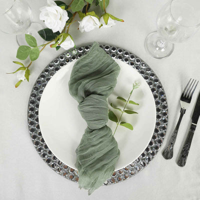 Elegant green napkin styled on a white plate with decorative charger and cutlery.