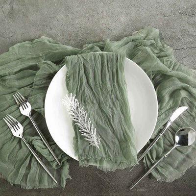 Elegant green table setting with linen napkin, plate, and silver cutlery.