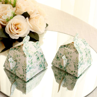 Floral gift boxes on a mirrored surface with roses in the background.
