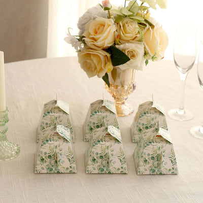 Decorative floral gift boxes arranged on a table with a bouquet of roses.